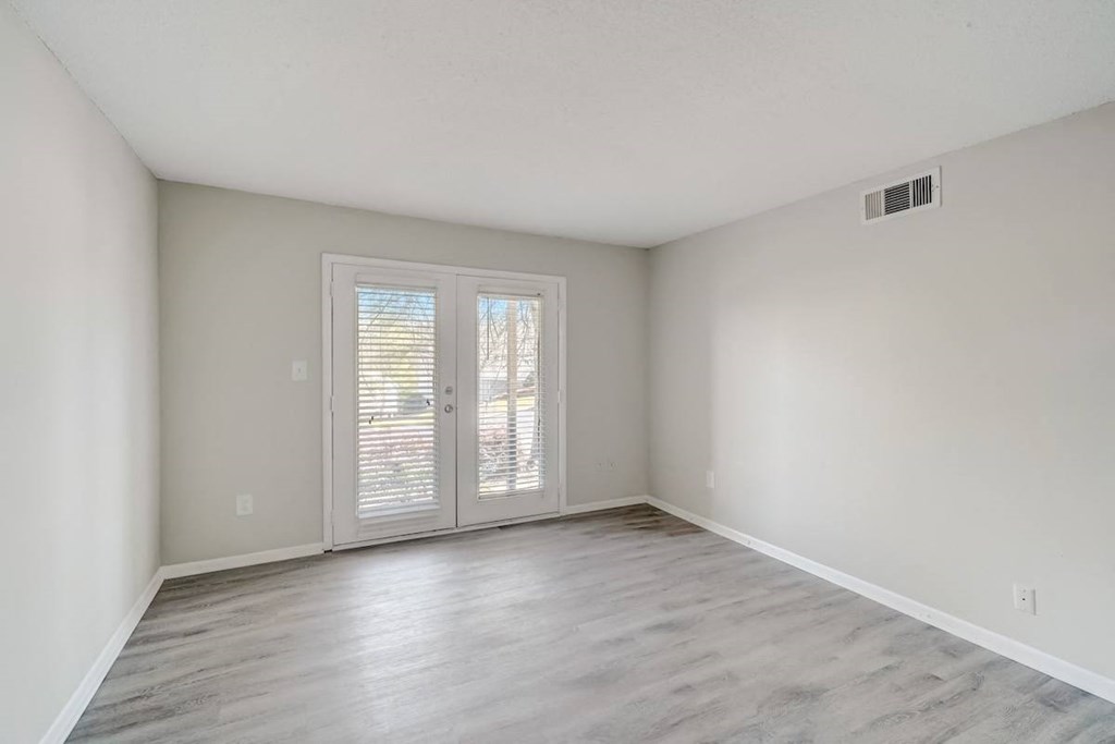 a living room with wood-style floors and french doors to a deck at Hills at Hoover 35216