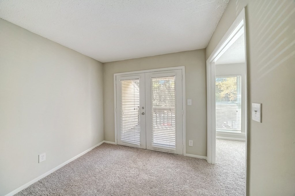 a dining and living area with french doors to a deck at Hills at Hoover 35216
