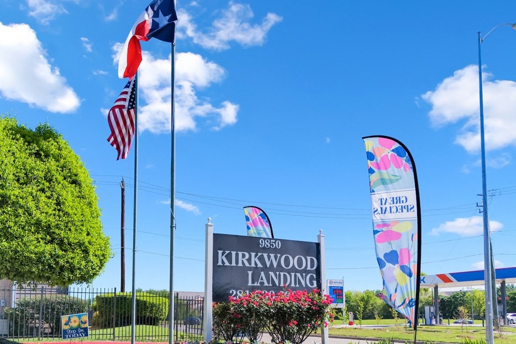 the entrance to kirkwood landing with flags and a sign