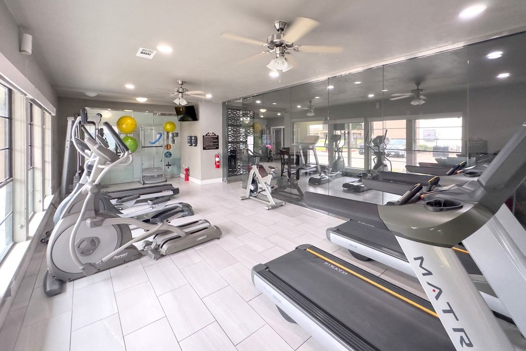 a gym with treadmills and other exercise equipment at Crosby at Westchase apartments in houston, tx