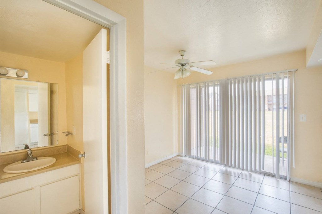 a bathroom with a sink and a ceiling fan and a sliding glass door