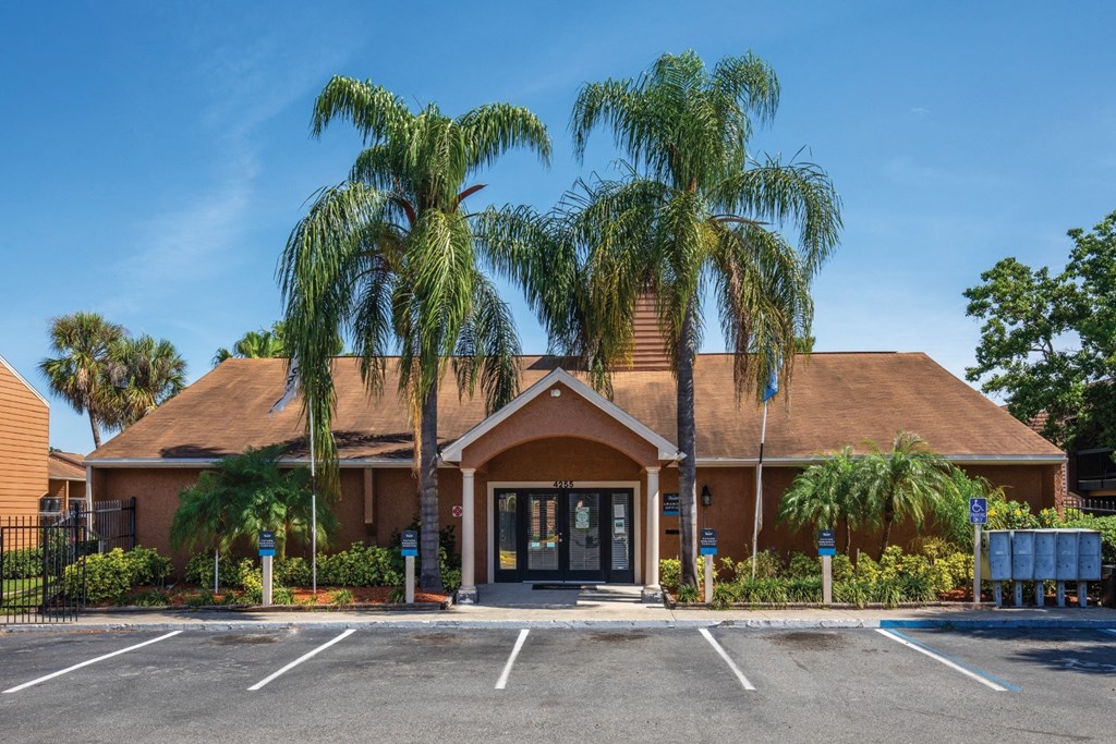 a building with palm trees in front of it in a parking lot