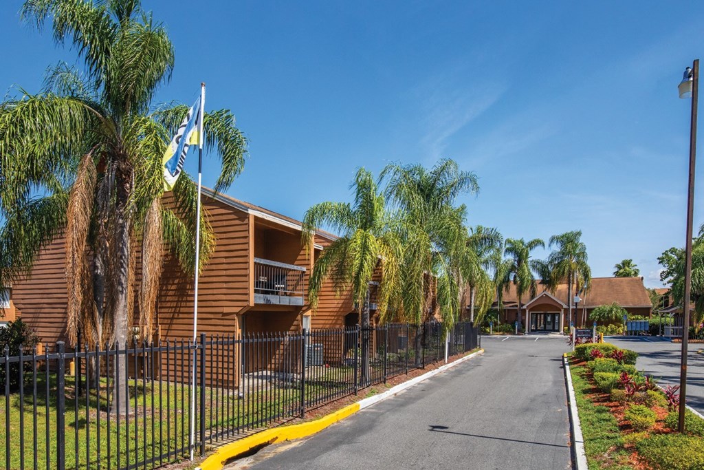 a building with palm trees on the side of a street