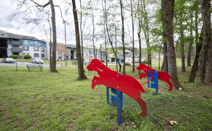 two red dogs on blue posts in a park at Crestwood Green, LLC, Birmingham, AL 35212
