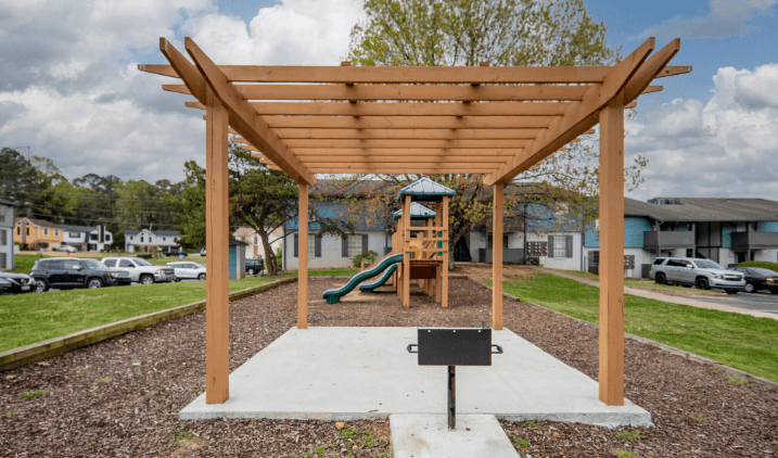 a picnic shelter with a play structure in the middle of a park at Crestwood Green, LLC, Alabama