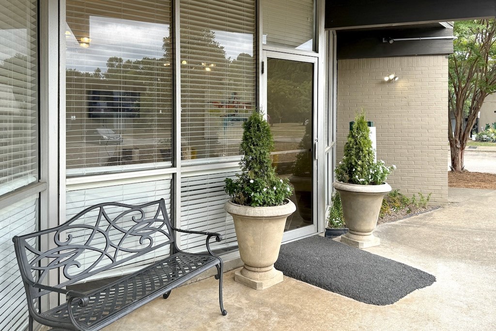 a bench and potted plants in front of a building at Spring Lake Cove Apartments, Birmingham, 35215