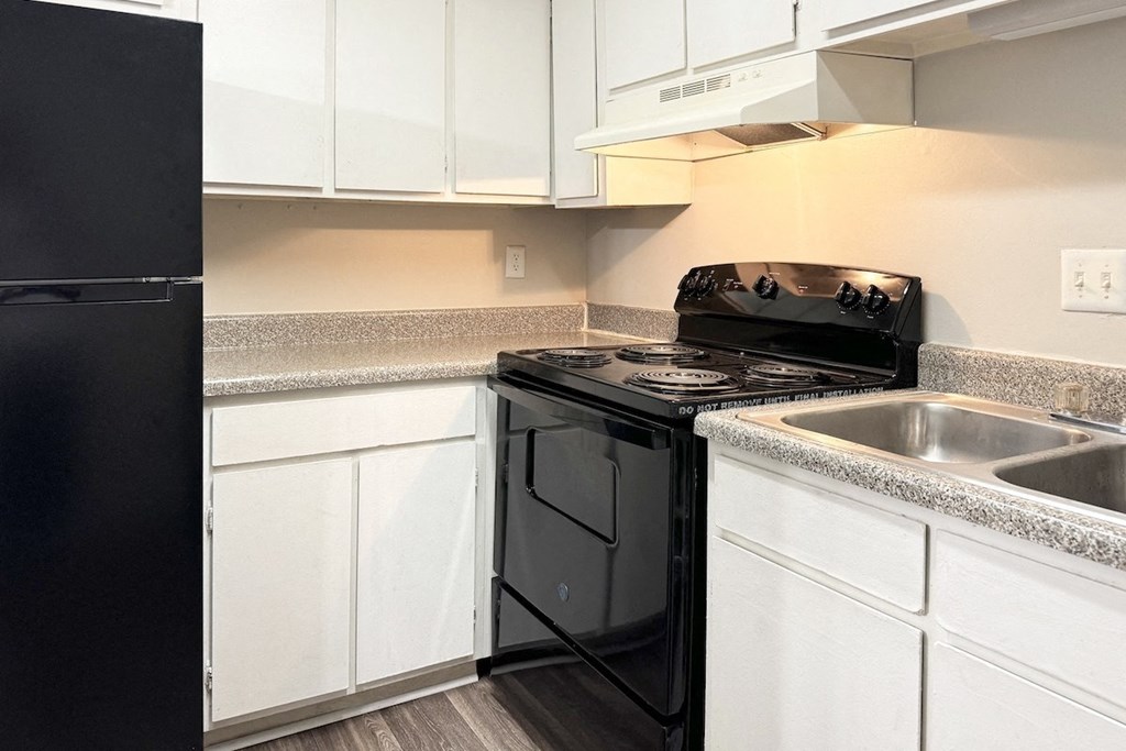 a kitchen with black appliances and white cabinets and a sink a kitchen with black appliances and white cabinets and a sink at Spring Lake Cove Apartments, Birmingham, AL 35215