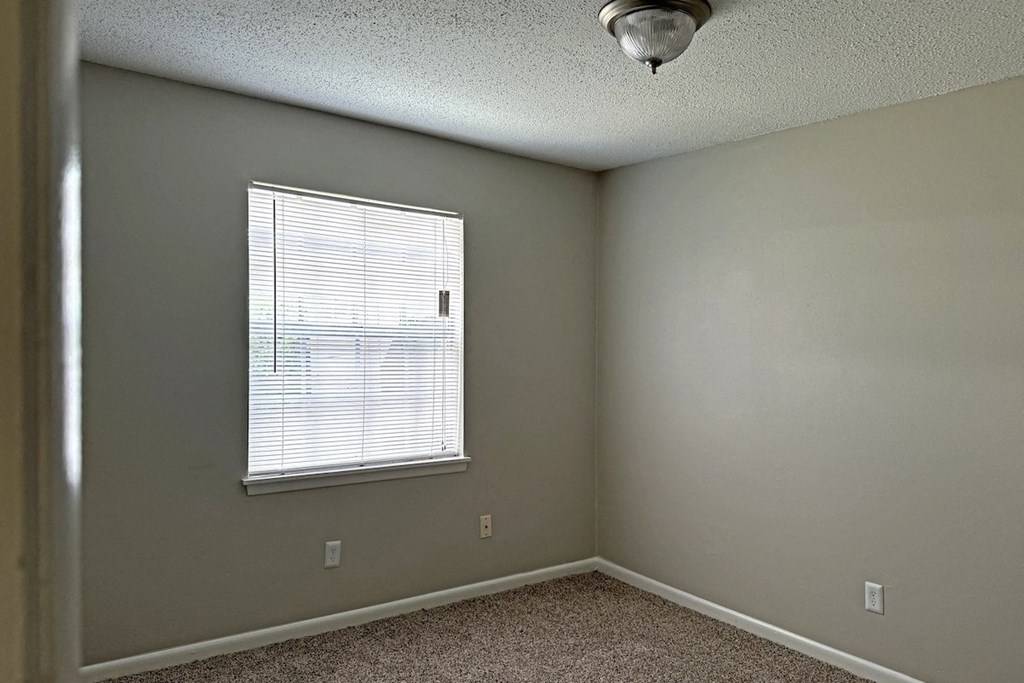 an empty bedroom with a window and a ceiling fan an empty bedroom with a window and a ceiling fan at Spring Lake Cove Apartments, Alabama