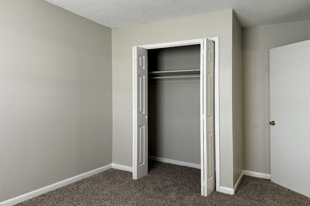 an empty closet in an empty room with a door open an empty closet in an empty room with a door open at Spring Lake Cove Apartments, Birmingham, AL