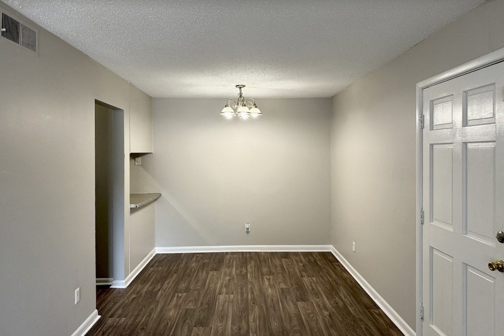 an empty living room with wood flooring and white walls an empty living room with wood flooring and white walls at Spring Lake Cove Apartments, Alabama, 35215