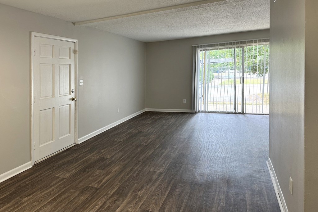 a spacious living room with a door and a sliding glass door to a private patio a spacious living room with a door and a sliding glass door to a private patio at Spring Lake Cove Apartments, Birmingham Alabama
