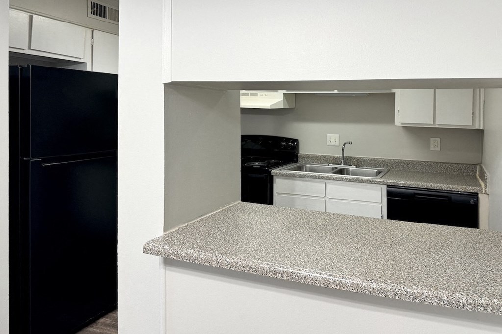 a kitchen with a granite counter top and a black refrigerator a kitchen with a granite counter top and a black refrigerator at Spring Lake Cove Apartments, Birmingham, AL