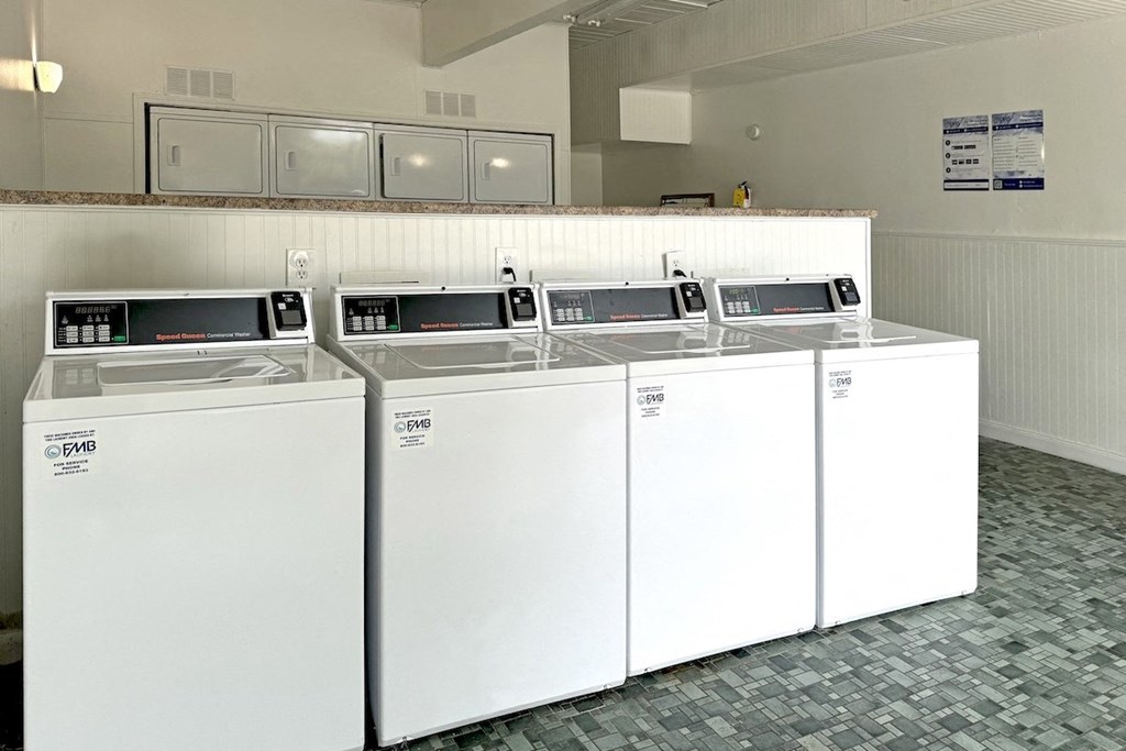 four washers and dryers in a row in a hotel laundry room four washers and dryers in a row in a hotel laundry room at Spring Lake Cove Apartments, Alabama, 35215