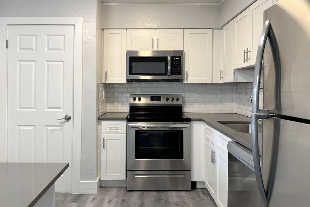 a kitchen with stainless steel appliances and white cabinets a kitchen with stainless steel appliances and white cabinets at Ascot Place Apartments, Birmingham, AL