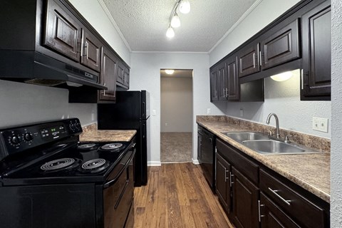 a kitchen with black appliances and dark wood cabinets