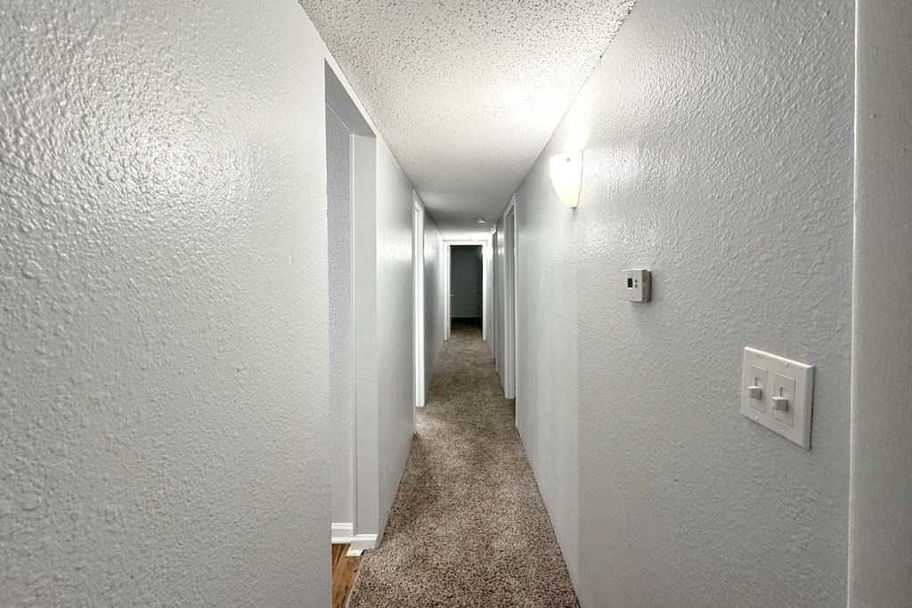 the hallway of a house with a carpeted floor and white walls the hallway of a house with a carpeted floor and white walls at Ascot Place Apartments, Birmingham