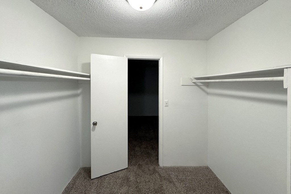 an empty closet in a room with a door open an empty closet in a room with a door open at Ascot Place Apartments, Birmingham, 35235