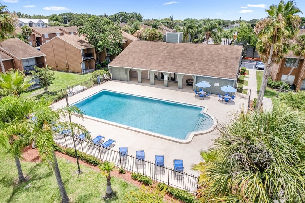 Winford Place offers a sparkling pool with loungers and shaded tables surrounded by lush pallms