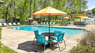 a swimming pool with a table and chairs and an umbrella at Crestwood Green, LLC, Birmingham - Photo Gallery 5