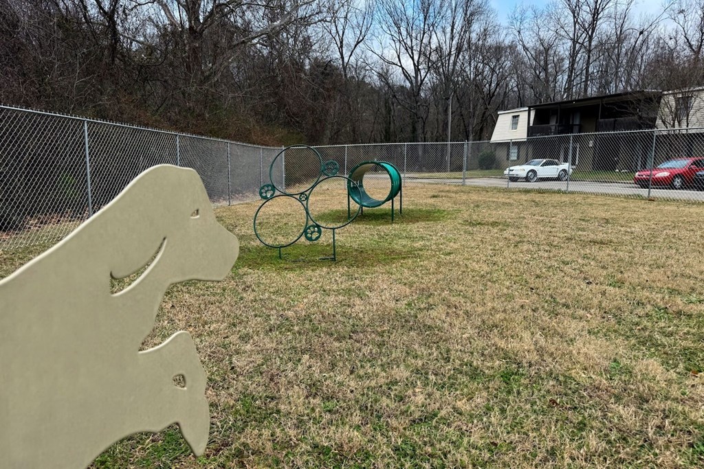 A playground with a slide and a seesaw in a grassy area.