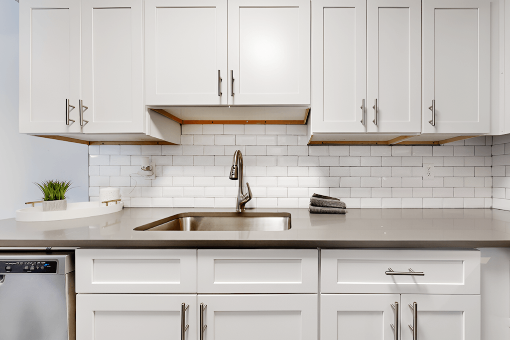 kitchen with tile backsplash, white cabinets, and stainless steel sink kitchen with tile backsplash, white cabinets, and stainless steel sink at Spring Lake Cove Apartments, Birmingham, 35215