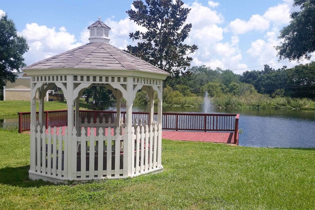 Serenity-Lake_PG-64 a large gazebo by a pond with a fountain at Serenity Lake Apartments