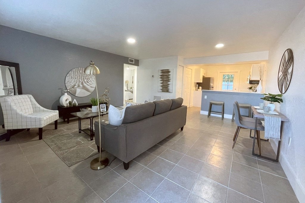 a model apartment living room with furnishings and a tile floor at Serenity Lake