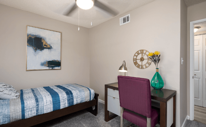 a bedroom with a bed and a desk with a chair at Crestwood Green, LLC, Birmingham, 35212
