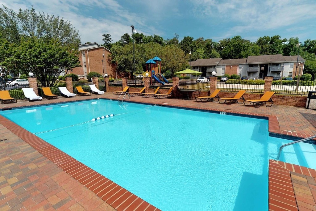 a swimming pool with orange lounge chairs around it a swimming pool with orange lounge chairs around it at Ascot Place Apartments, Birmingham Alabama