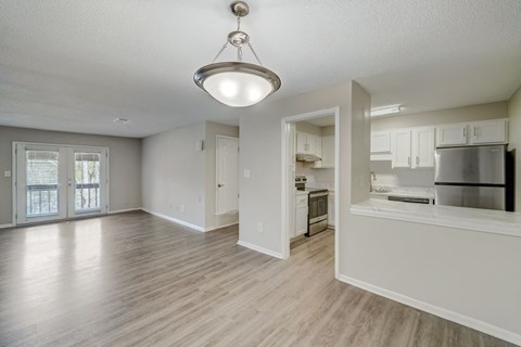 an empty living room and kitchen with an open floor plan