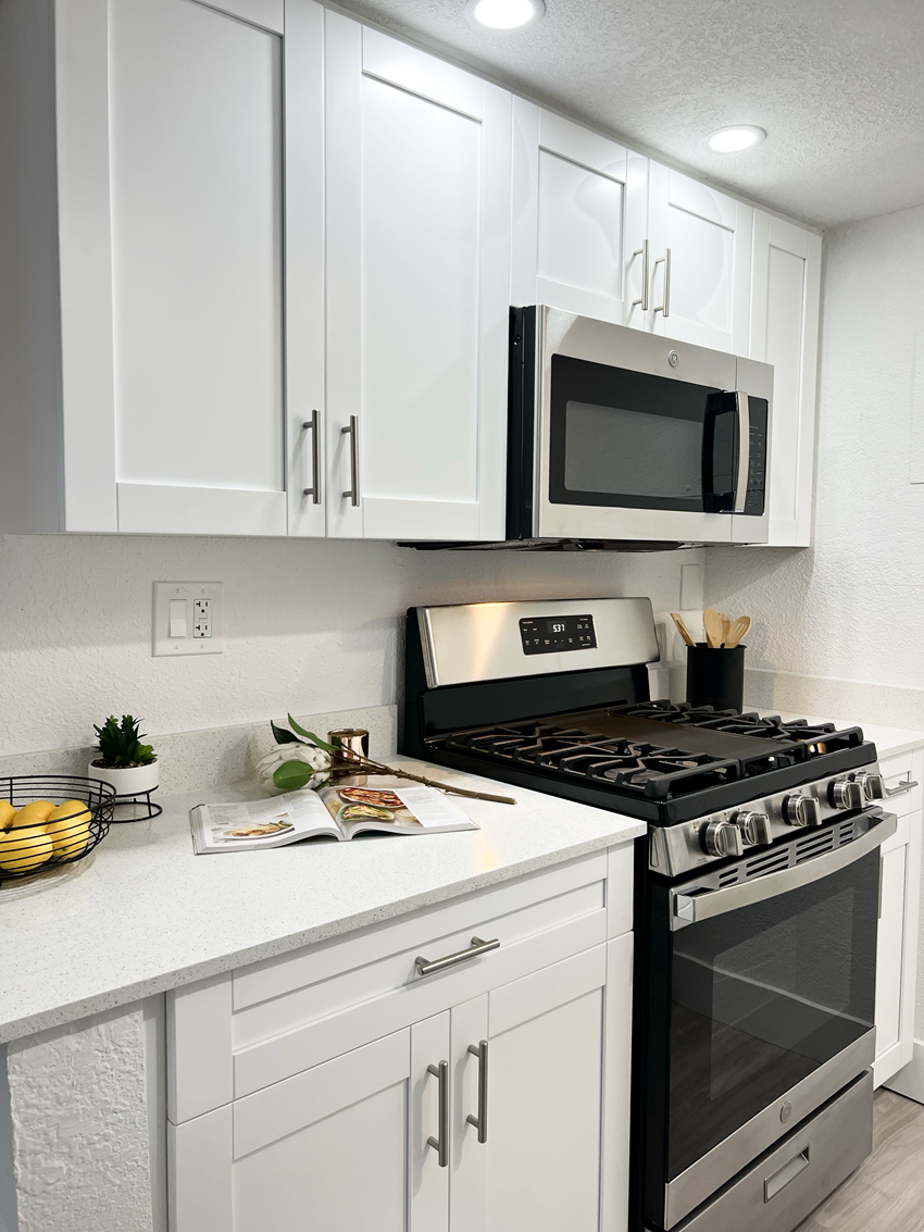 a kitchen with white cabinets and stainless steel appliances - Photo Gallery