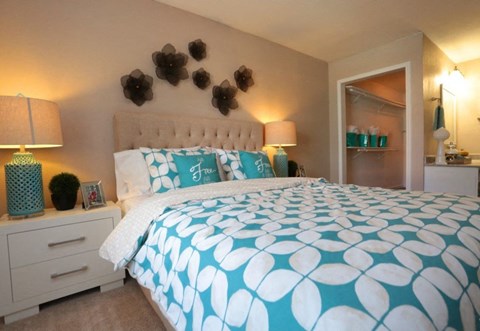 a bedroom with a large bed and a blue and white comforter