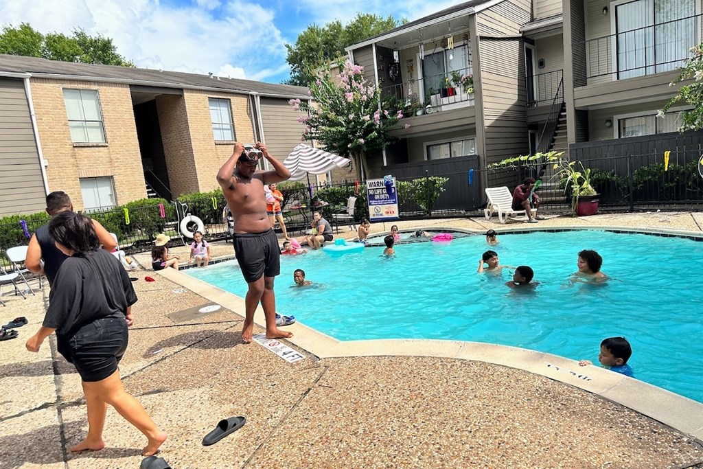 A group of people are enjoying a sunny day at a pool.