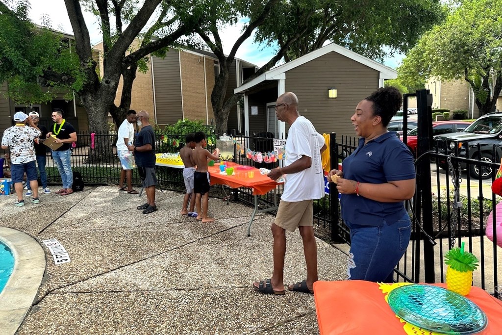 A group of people are gathered around a table with a pineapple design on it.