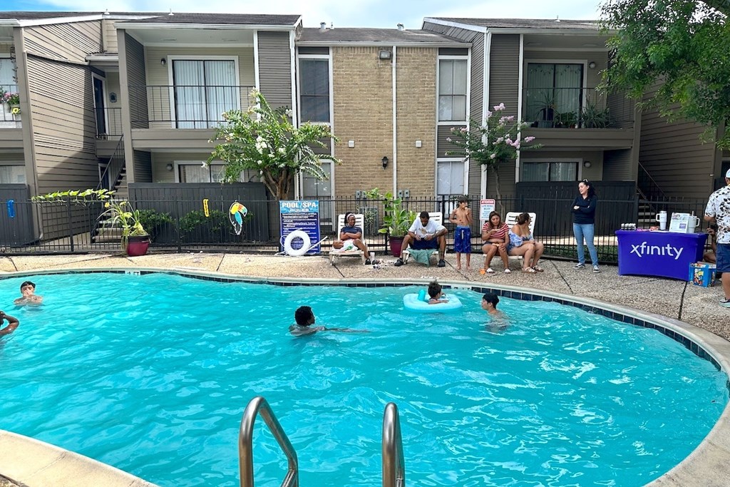 A group of people are gathered around a pool.