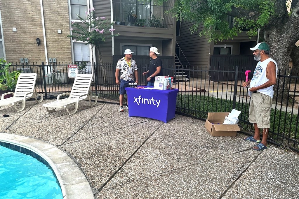Three men are standing around a purple box labeled