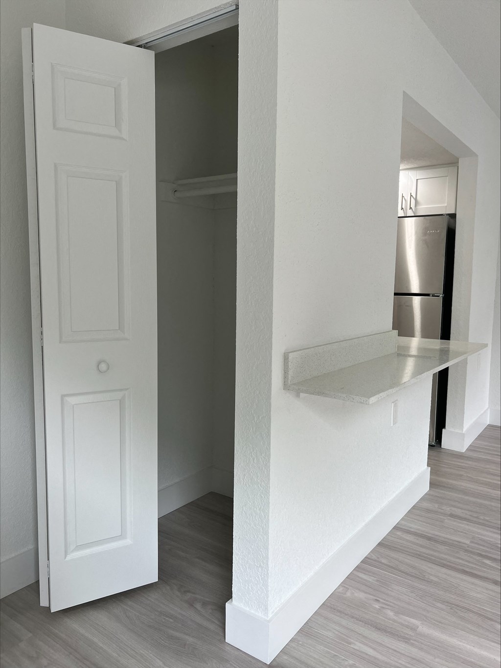 a bedroom with a large white door and a white shelf on the wall