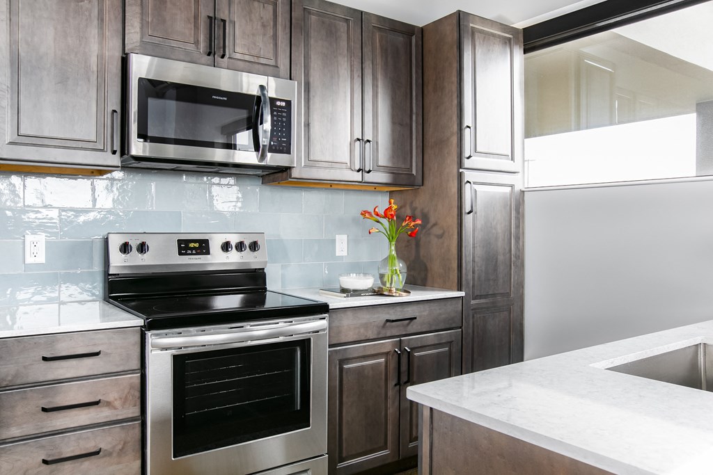 a modern kitchen with stainless steel appliances and wooden cabinets