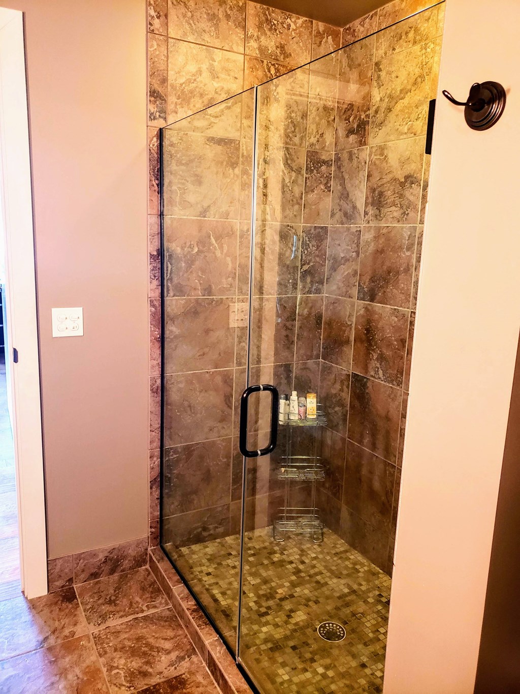 a large shower with a glass door in a bathroom
