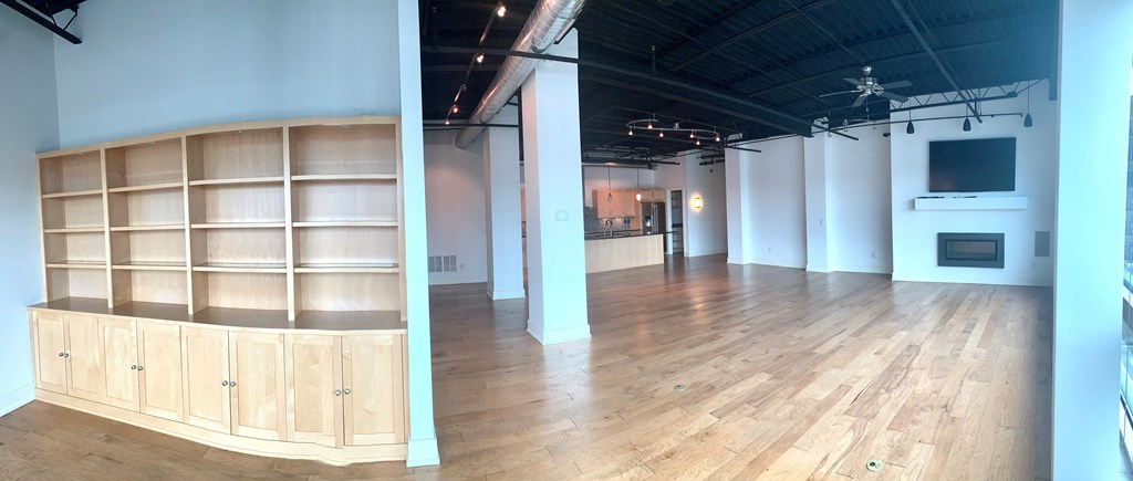 a large room with a wood floor and a tv in it