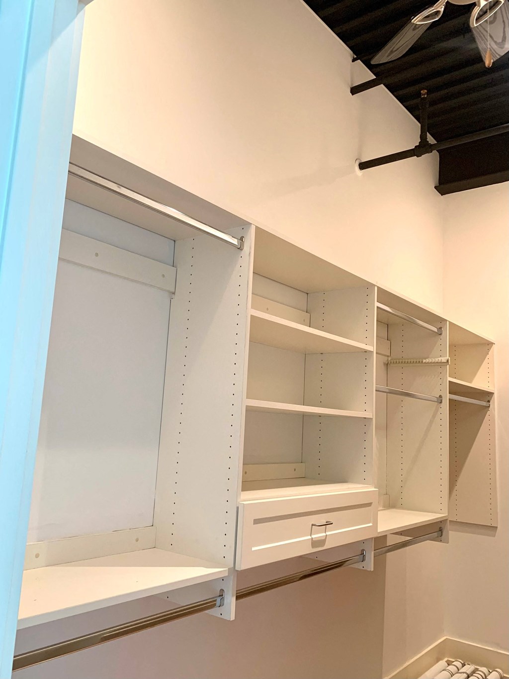 a built in closet with white shelving and a white closet door