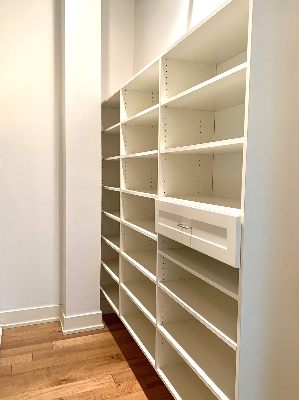 a walk in closet with empty shelves