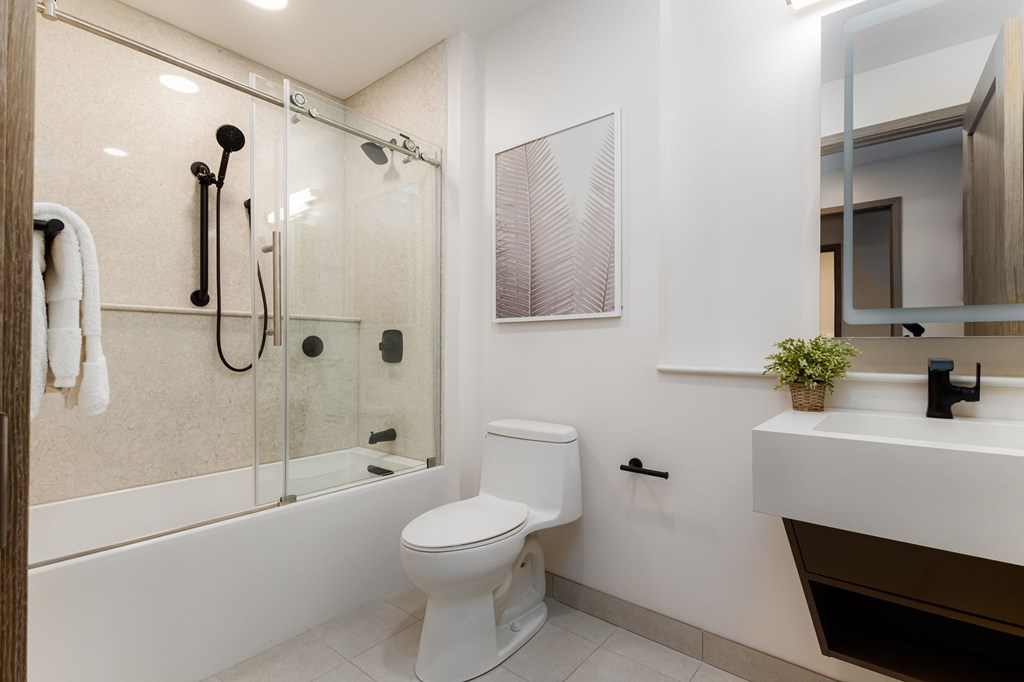 A white toilet in a modern bathroom with a glass shower.