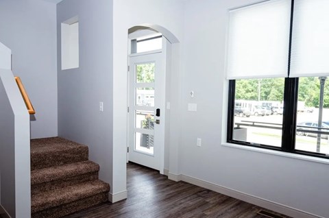 A hallway with a staircase leading to the second floor.