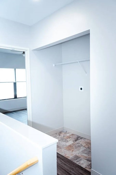 A white hallway with a door and a window.