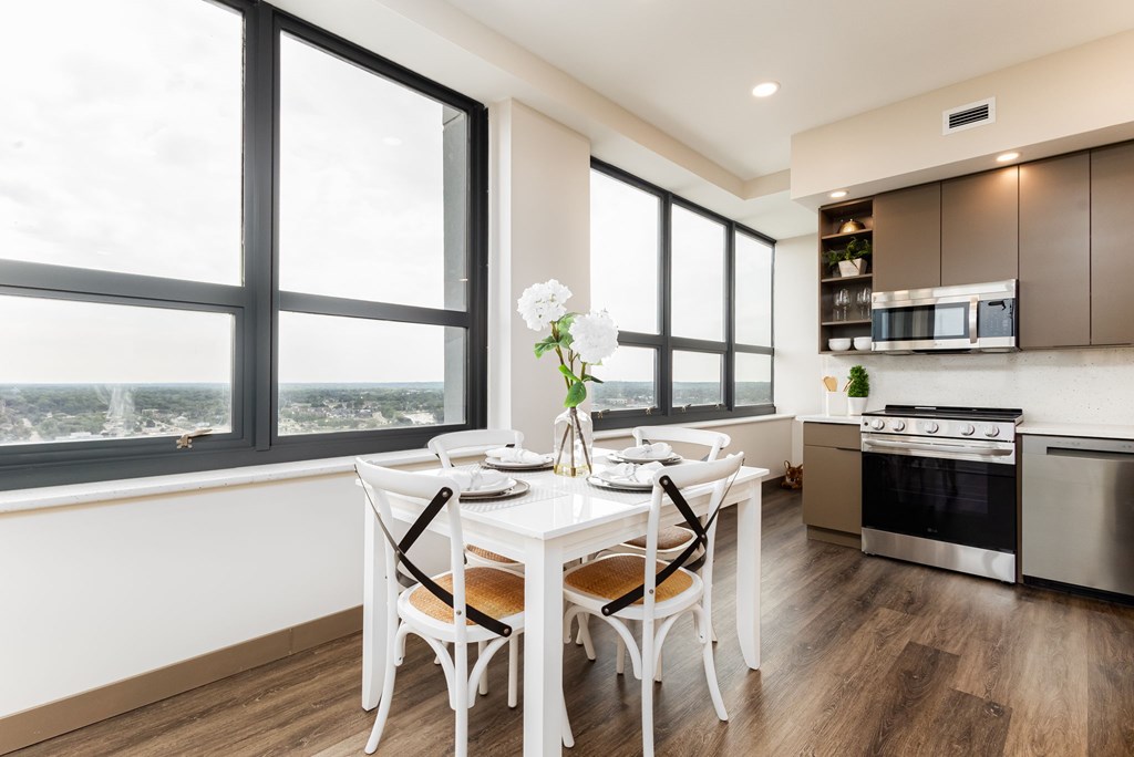 A modern kitchen with a dining table set for two.