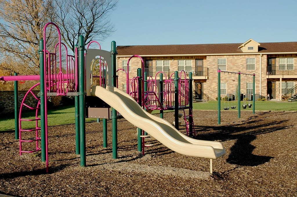a slide on a playground in front of a building