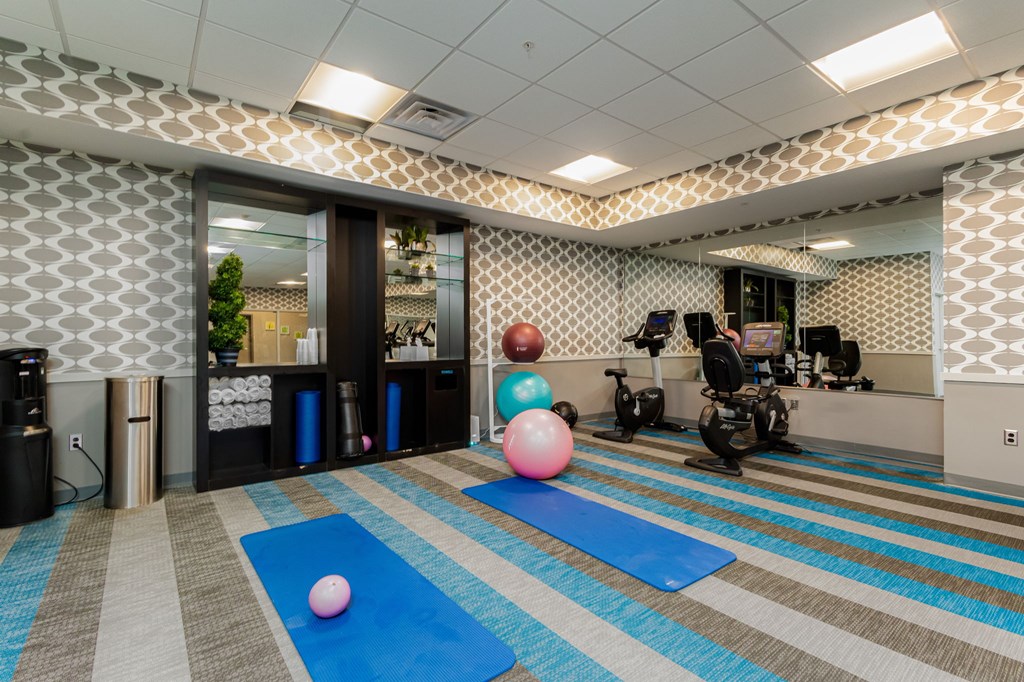A room with exercise equipment and yoga mats.