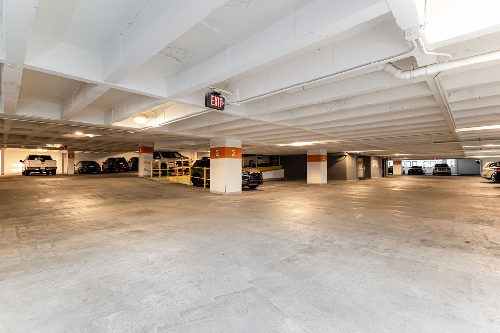 A parking garage with a sign that says "EXIT" on the ceiling.