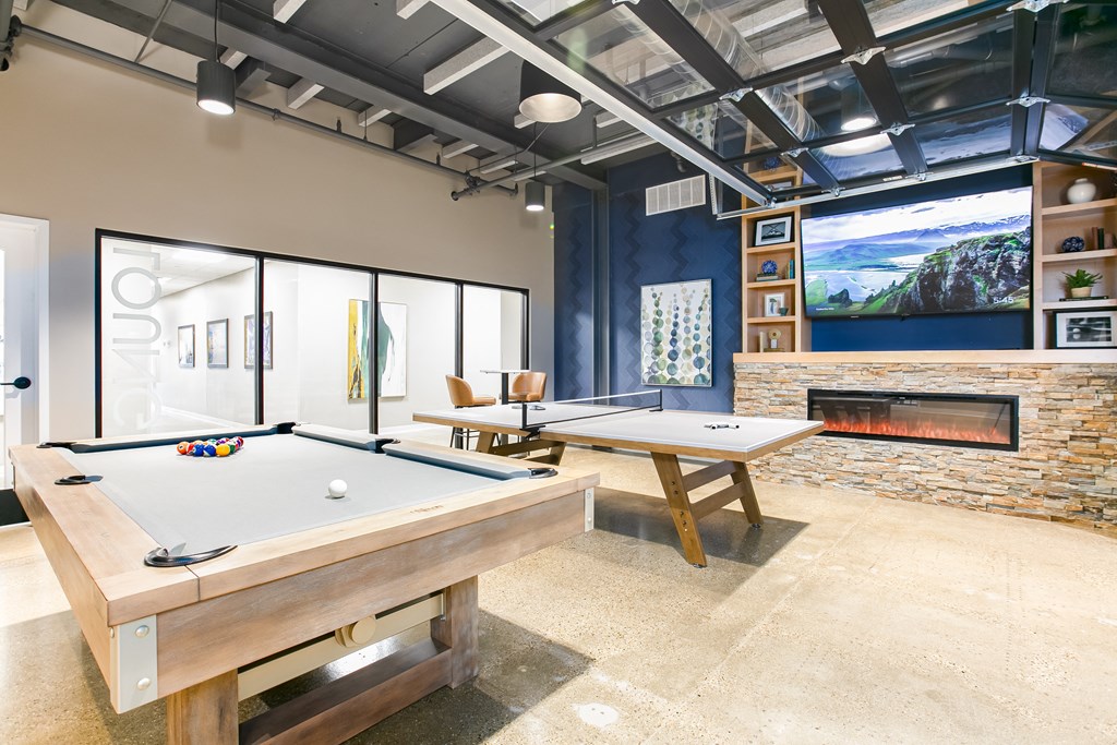 a game room with two pool tables and a fireplace